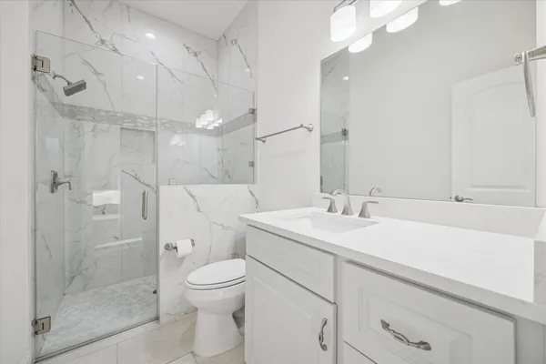 a bathroom with a sink a toilet and shower