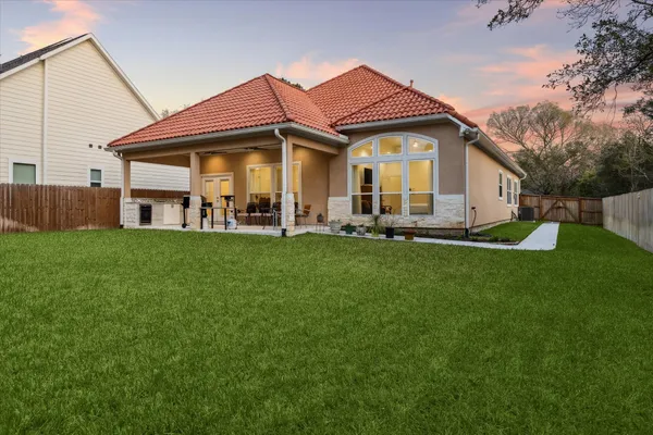 a front view of a house with a garden and trees