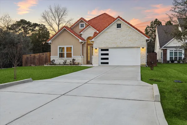 a view of house with a yard and garage