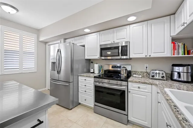 a kitchen with stainless steel appliances granite countertop a refrigerator stove and sink