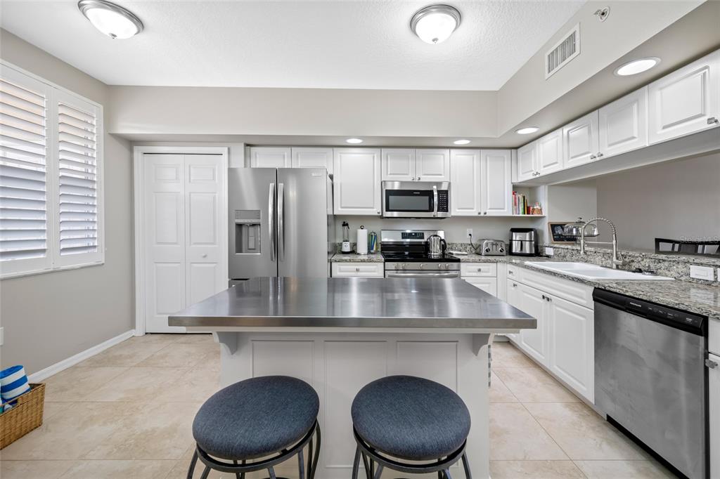 960 Starkey Road, Unit 5504 Largo, FL 33771 - Photo 12 of 46 a kitchen with kitchen island granite countertop a sink counter top space appliances and cabinets