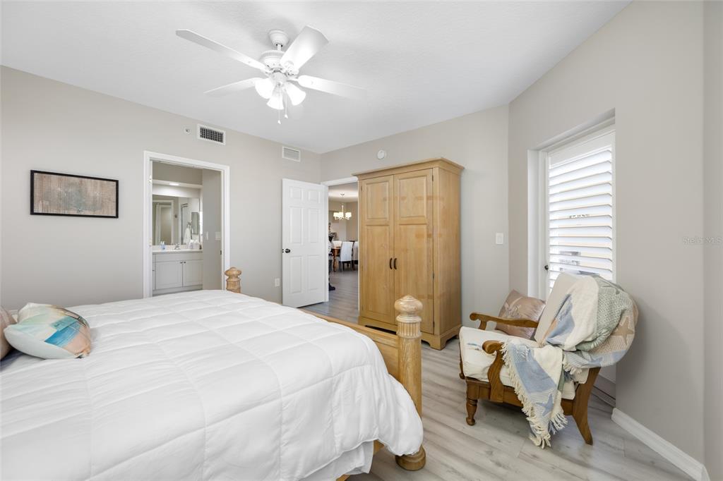 960 Starkey Road, Unit 5504 Largo, FL 33771 - Photo 23 of 46 a spacious bedroom with a bed and a chandelier