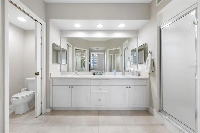 a spacious bathroom with a granite countertop sink a toilet and a mirror