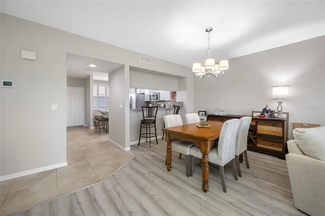 a dining room with furniture a chandelier and wooden floor