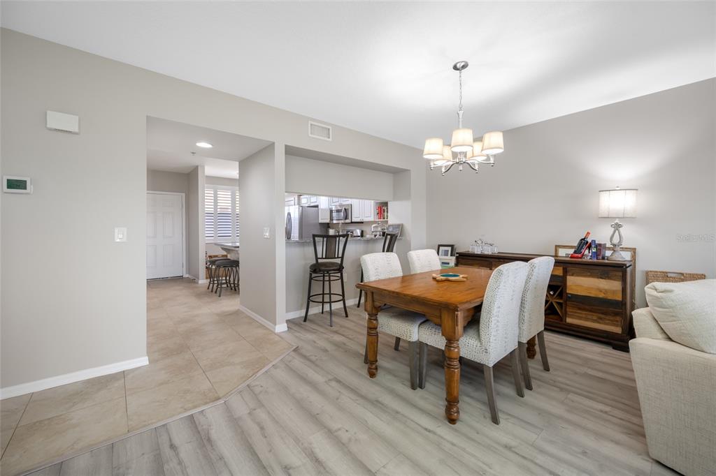 960 Starkey Road, Unit 5504 Largo, FL 33771 - Photo 31 of 46 a dining room with furniture a chandelier and wooden floor