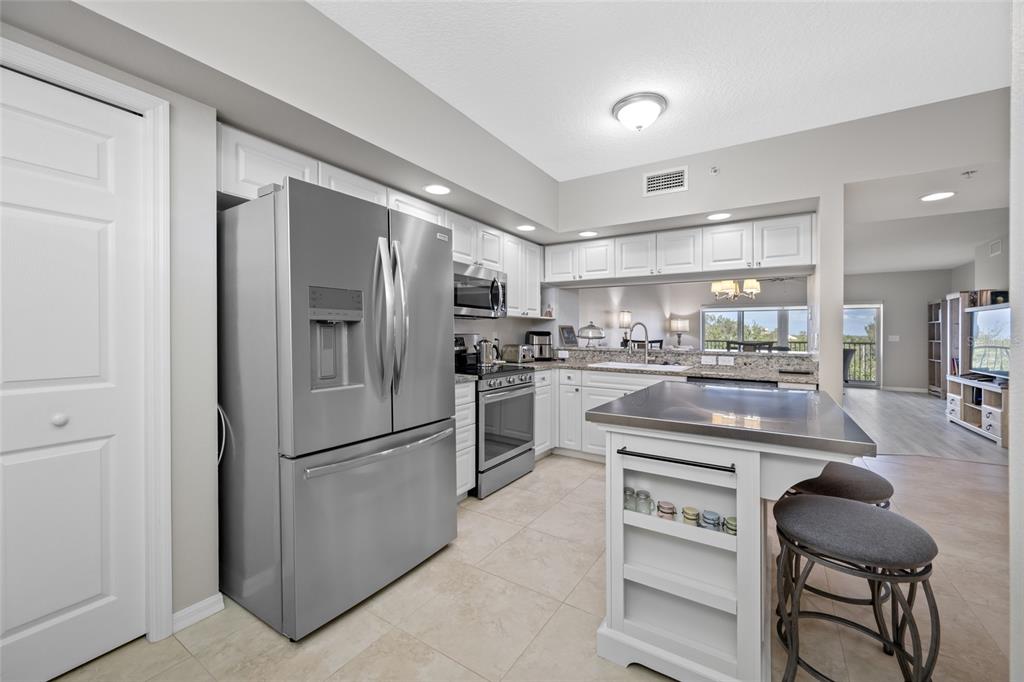 960 Starkey Road, Unit 5504 Largo, FL 33771 - Photo 9 of 46 a kitchen with a refrigerator a sink and chairs