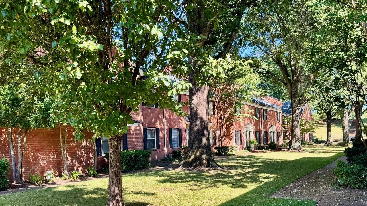 a front view of a building with trees in the background