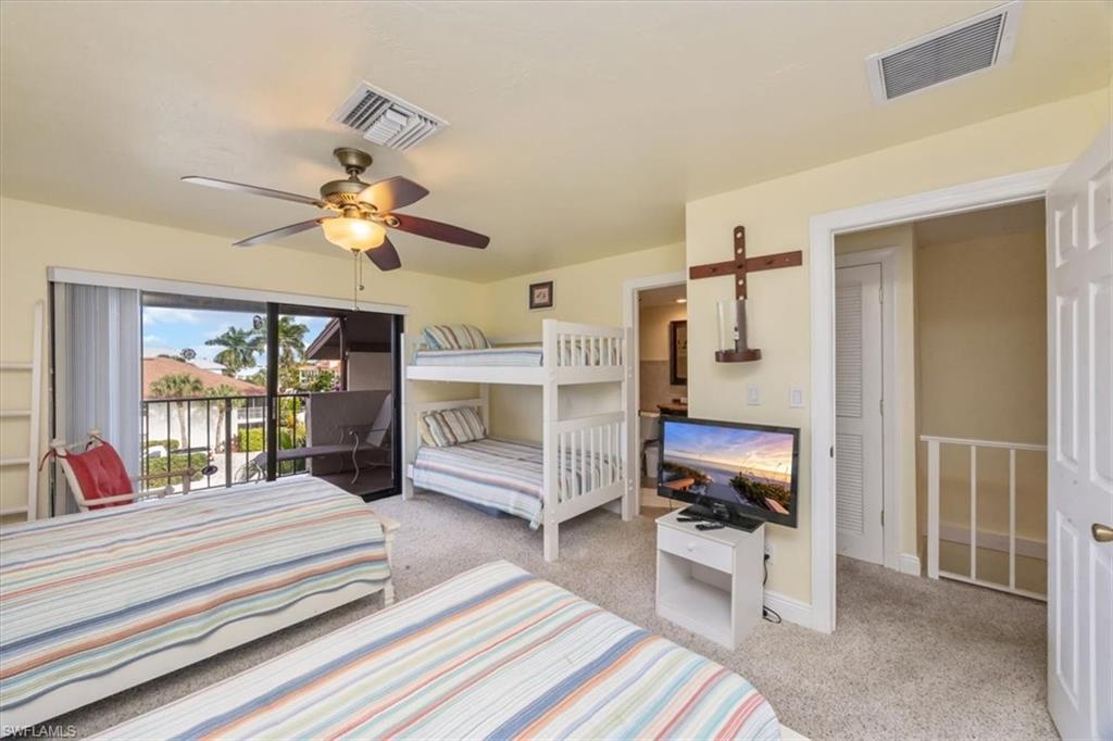 1400 Blue Point Avenue, Unit 208 Naples, FL 34102 - Photo 17 of 24 a bedroom with a bed and a chandelier