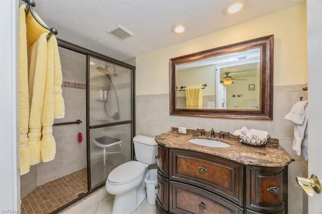a bathroom with a granite countertop toilet sink and mirror