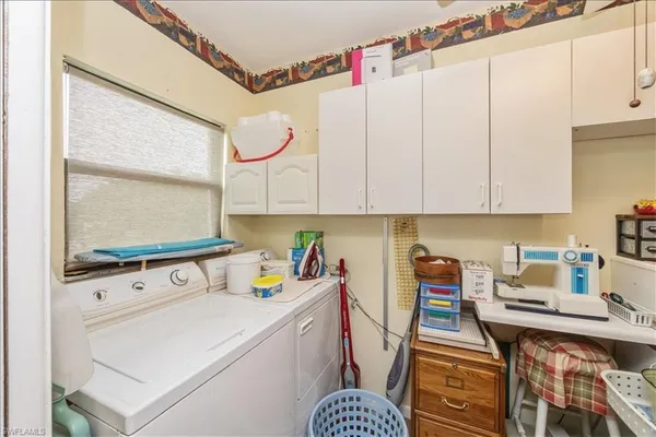 a utility room with cabinets washer and dryer