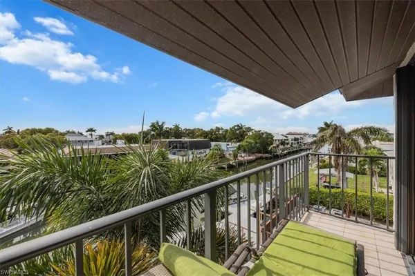 a view of a balcony with wooden floor & fence
