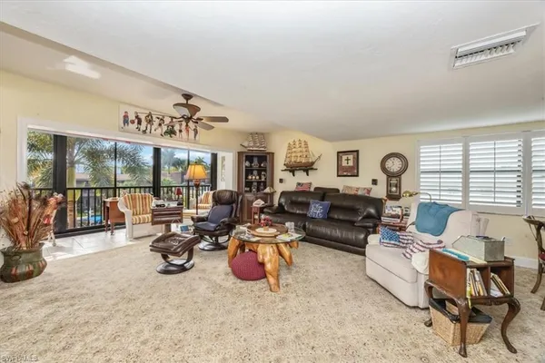 a living room with furniture a large window and glass door