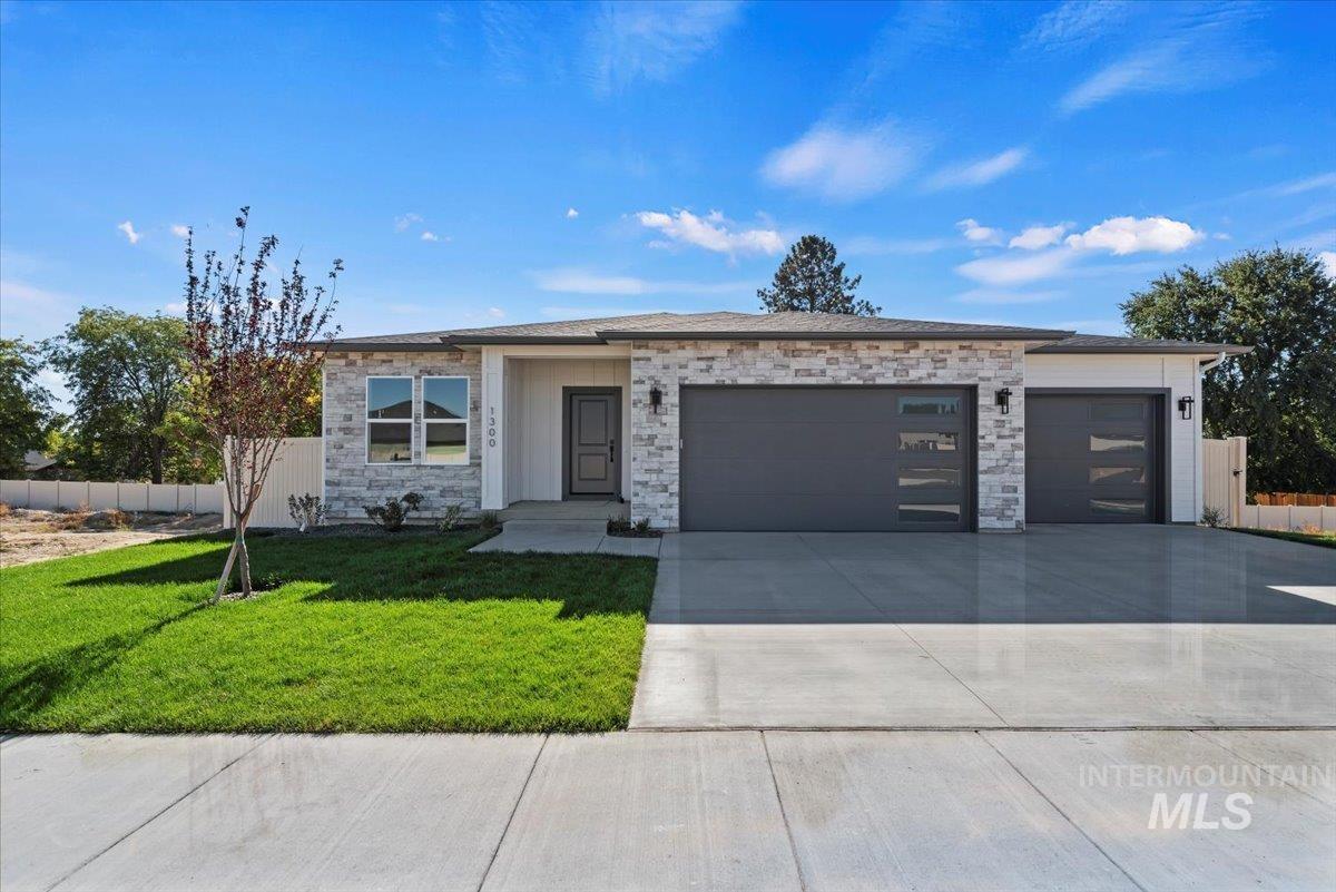 Prairie-style house with concrete driveway, stone siding, and an attached garage