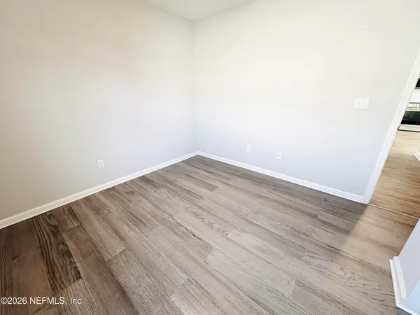 a view of empty room with wooden floor