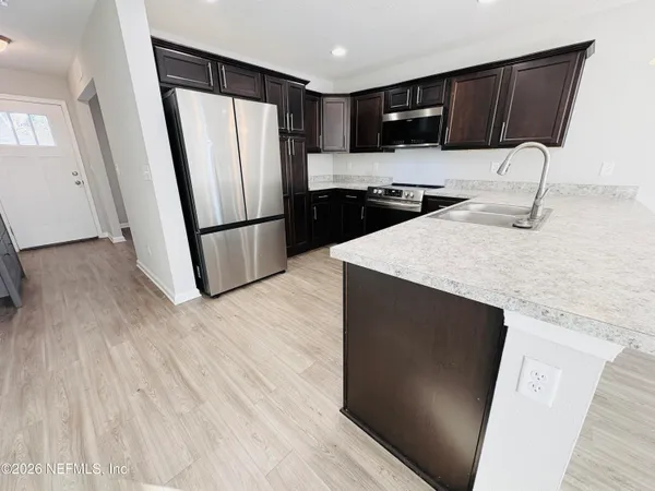 a kitchen with stainless steel appliances a refrigerator microwave and sink