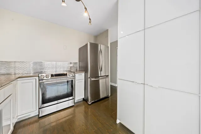 a kitchen with a refrigerator and a stove top oven