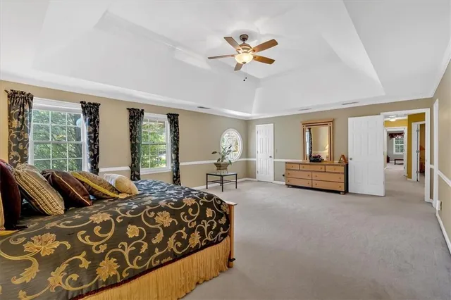 a spacious bedroom with a bed and a chandelier