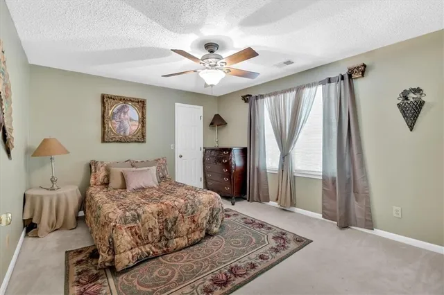 a bedroom with a large bed and a chandelier