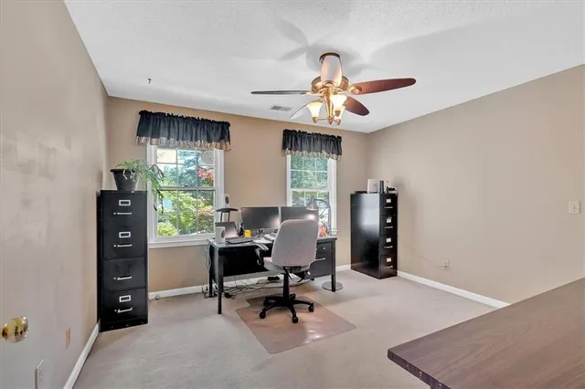 a view of a workspace with furniture and a window