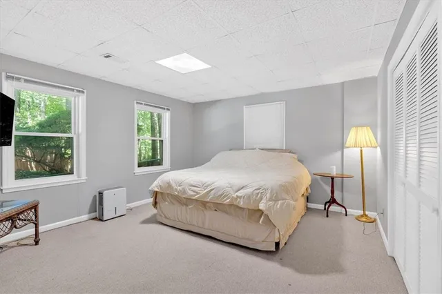 a large bed sitting in a bedroom next to a window
