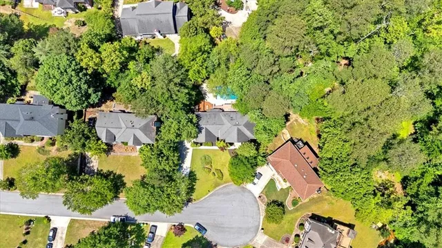 an aerial view of residential house with outdoor space and trees all around