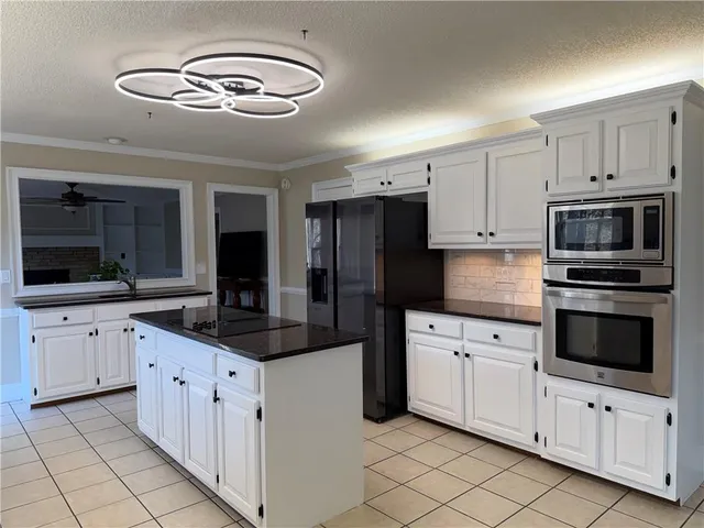 a kitchen with granite countertop a sink and stainless steel appliances