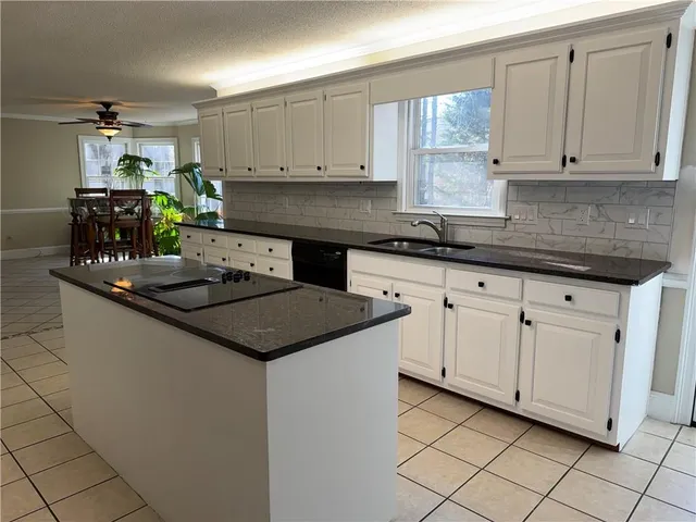 a kitchen with white cabinets and appliances