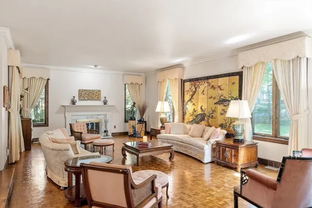 a living room with fireplace furniture and a large window