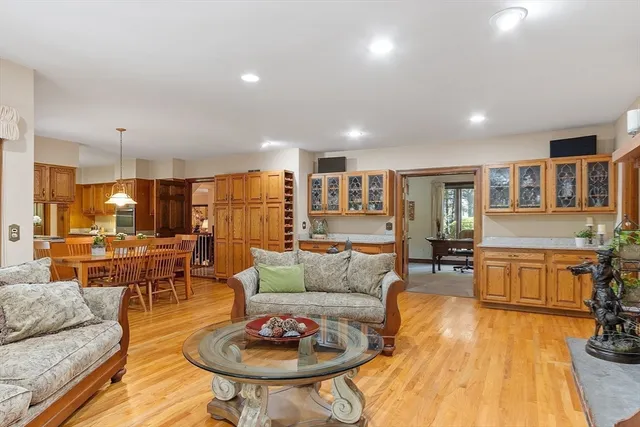 a living room with furniture kitchen view and a wooden floor