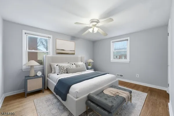 a bedroom with a bed and a lamp on dresser