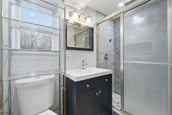 a bathroom with a bathtub shower sink vanity and mirror