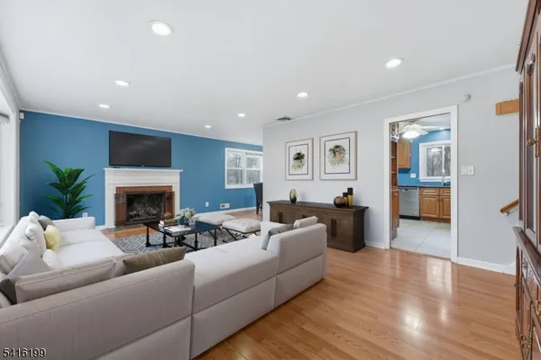 a living room with furniture a fireplace and a view of kitchen
