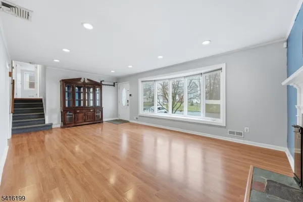 a view of an empty room with a window and a kitchen