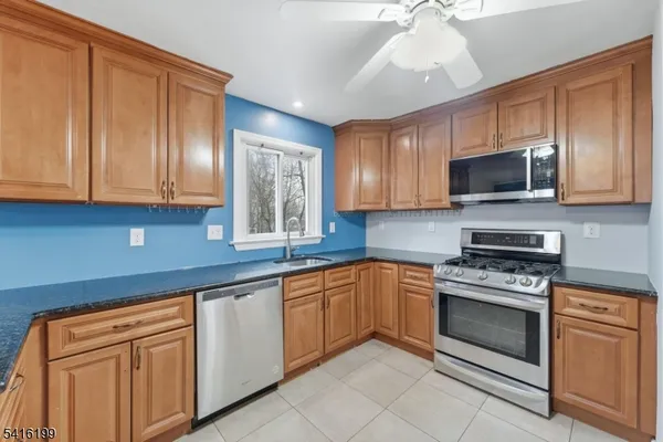 a kitchen with cabinets stainless steel appliances and a window