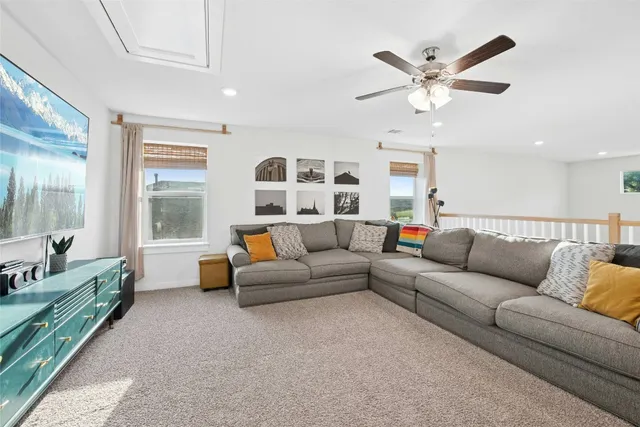 a living room with furniture a ceiling fan and a rug