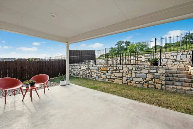 a view of a chairs and table in the back yard of the house