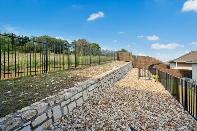 a view of a pathway with a wrought fence