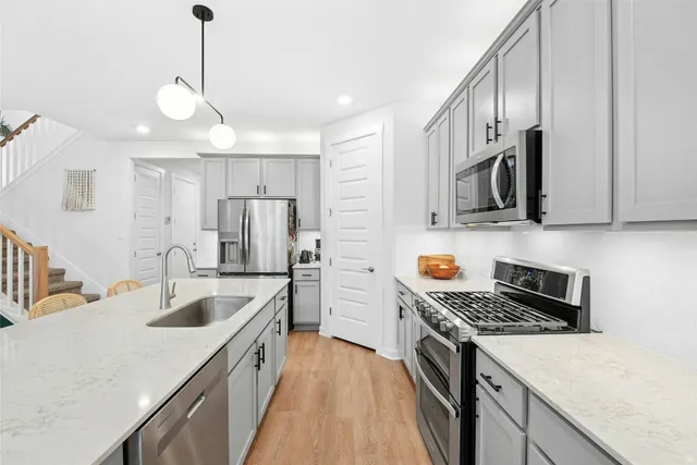 a kitchen with granite countertop a sink a stove and a microwave oven