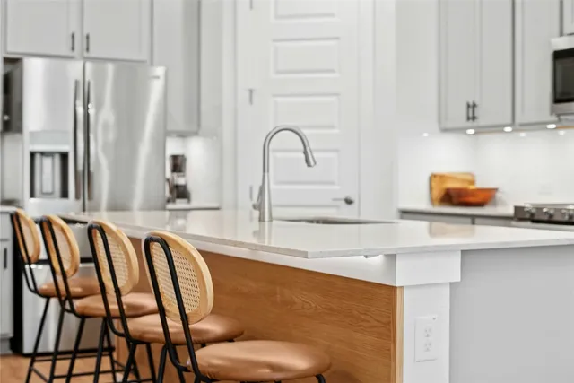 a kitchen with stainless steel appliances granite countertop a sink stove and refrigerator