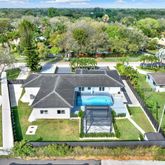 an aerial view of a house with a yard basket ball court and outdoor seating