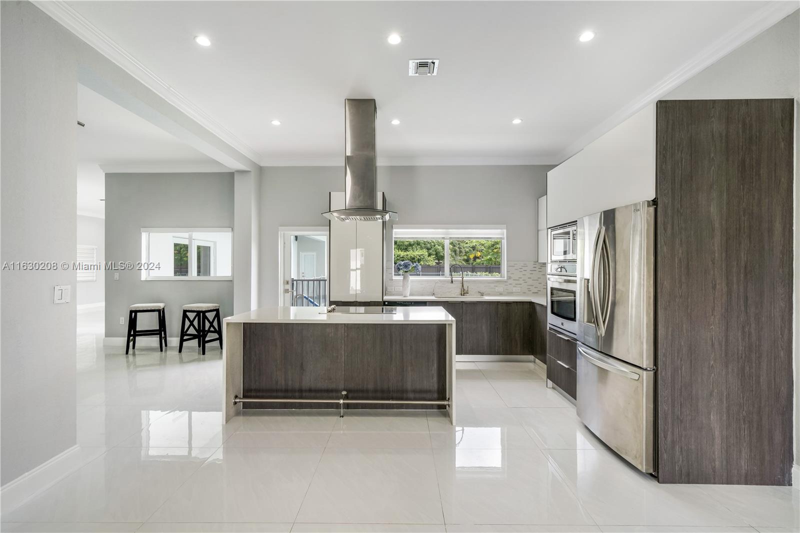 11921 Southwest 82nd Road Miami, FL 33156 - Photo 12 of 32 a kitchen with refrigerator and chairs