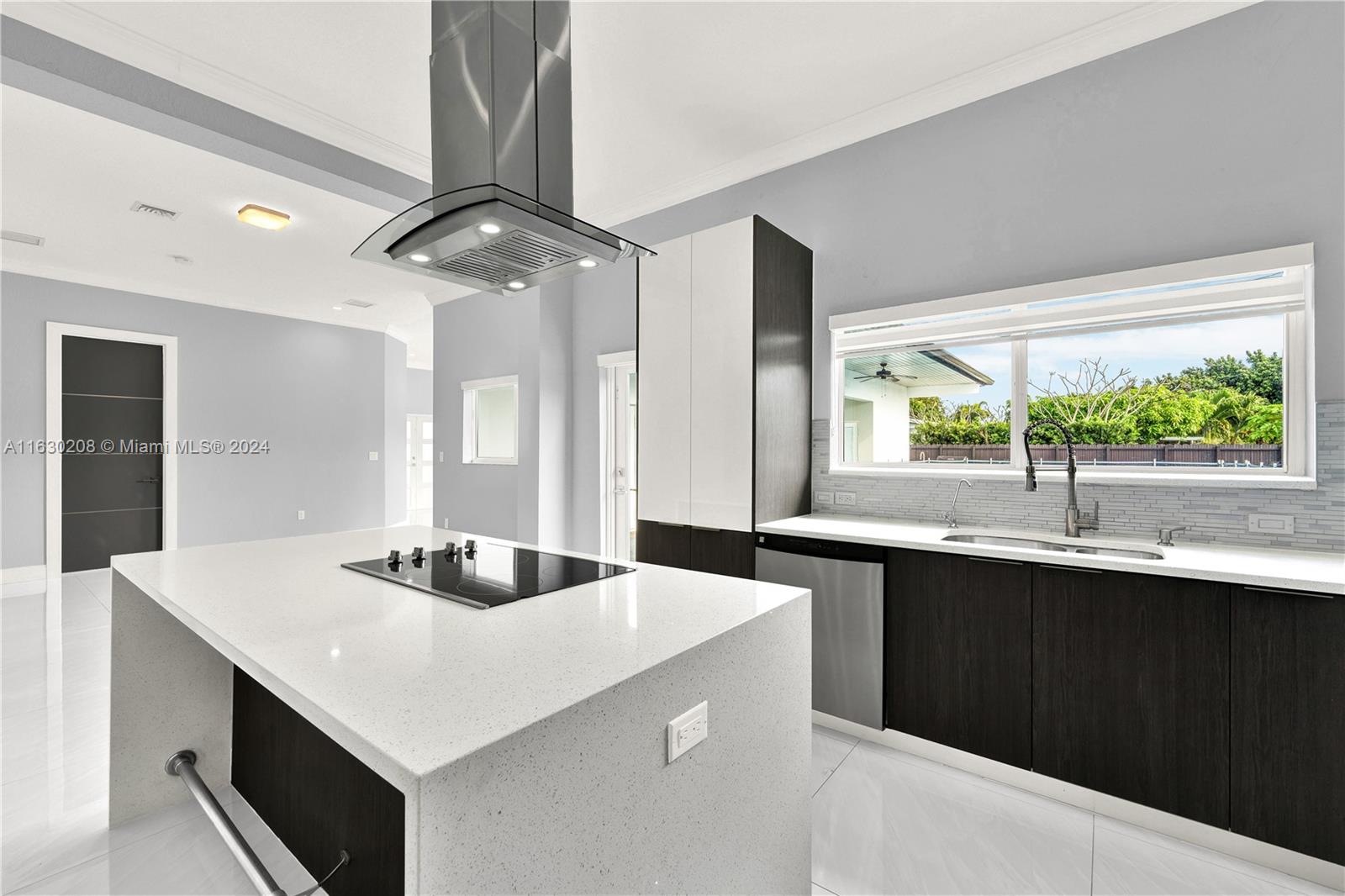 11921 Southwest 82nd Road Miami, FL 33156 - Photo 4 of 32 a kitchen with sink cabinets and chandelier