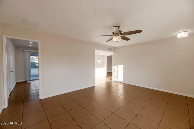 a view of an empty room and a ceiling fan
