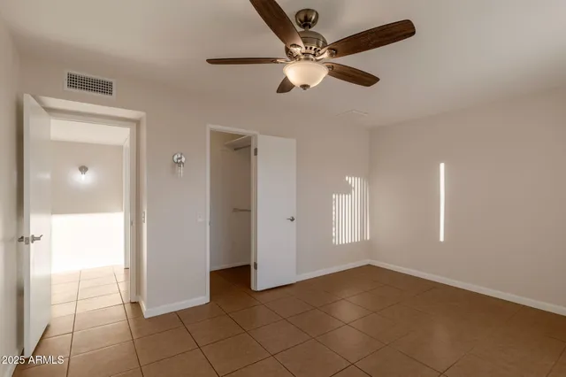 a view of a livingroom with a chandelier fan and windows