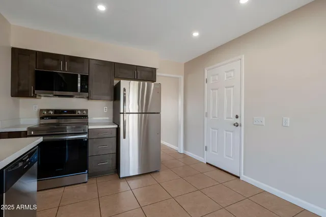 a kitchen with stainless steel appliances a refrigerator and a stove top oven