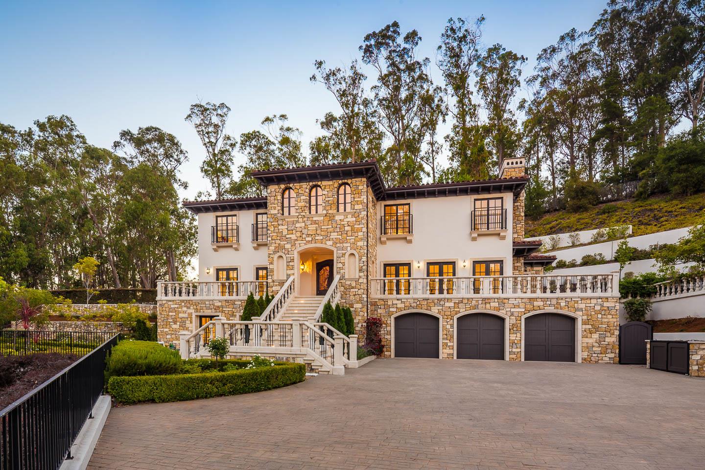 a view of a white house with a large tree