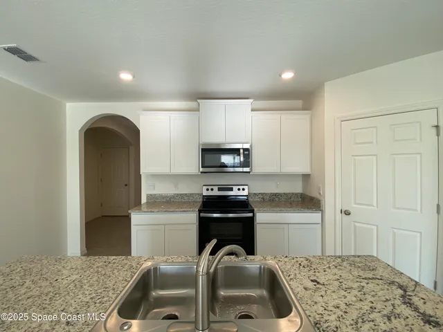 a kitchen with sink refrigerator and stove