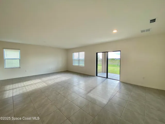 a view of an empty room with window and fireplace