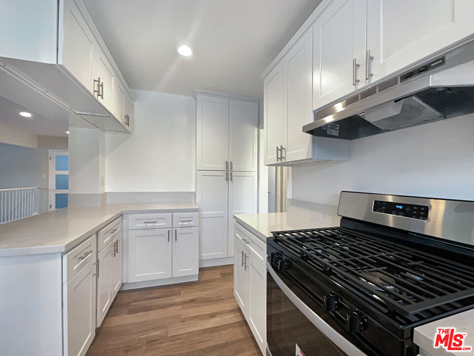 7944 Limerick Avenue Winnetka, CA 91306 - Photo 13 of 23 a kitchen with white cabinets and appliances