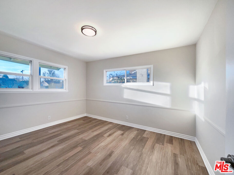 7944 Limerick Avenue Winnetka, CA 91306 - Photo 14 of 23 a view of empty room with wooden floor and fan